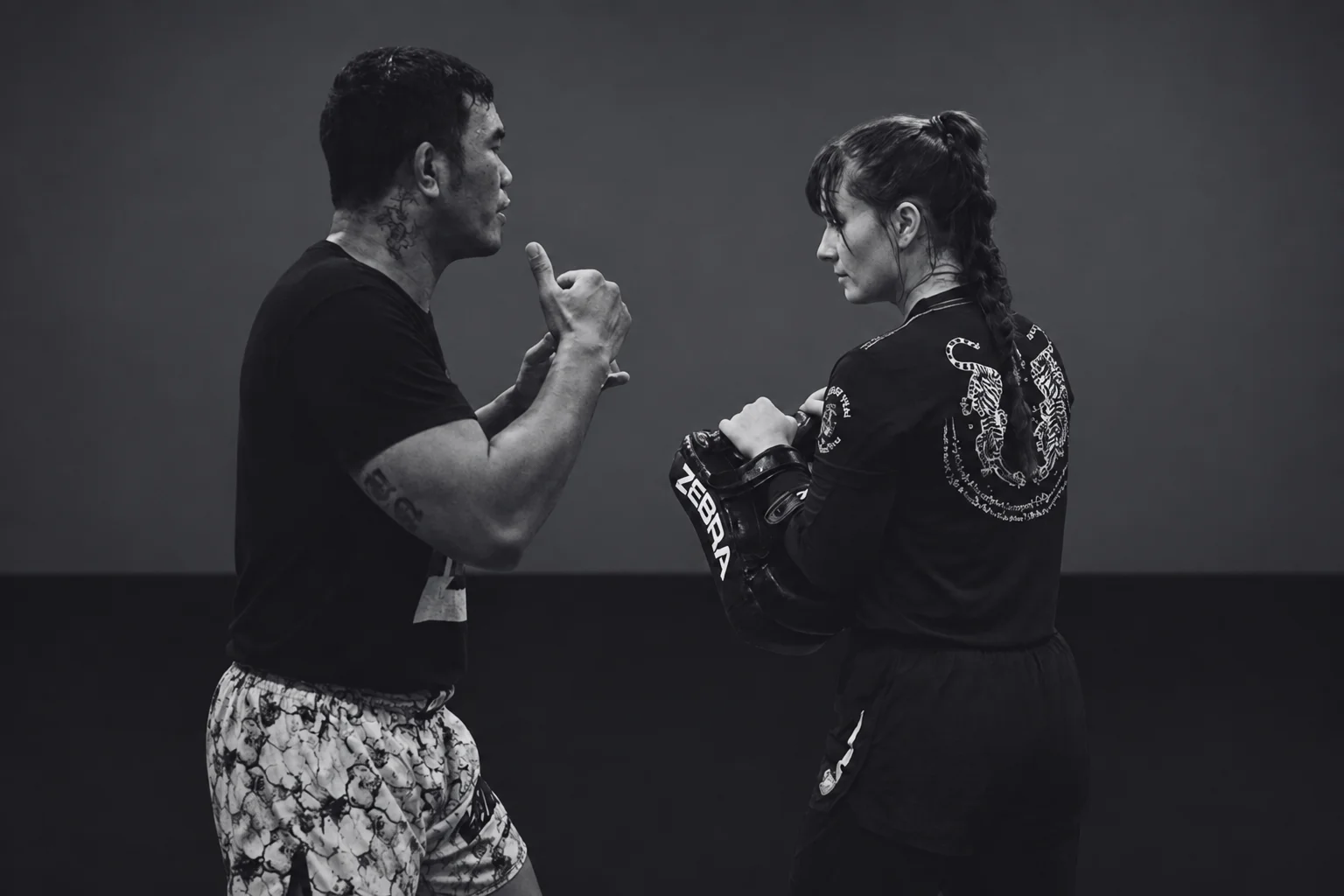 Trainer und Athletin beim Muay-Thai-Training, Schwarz-Weiß-Aufnahme