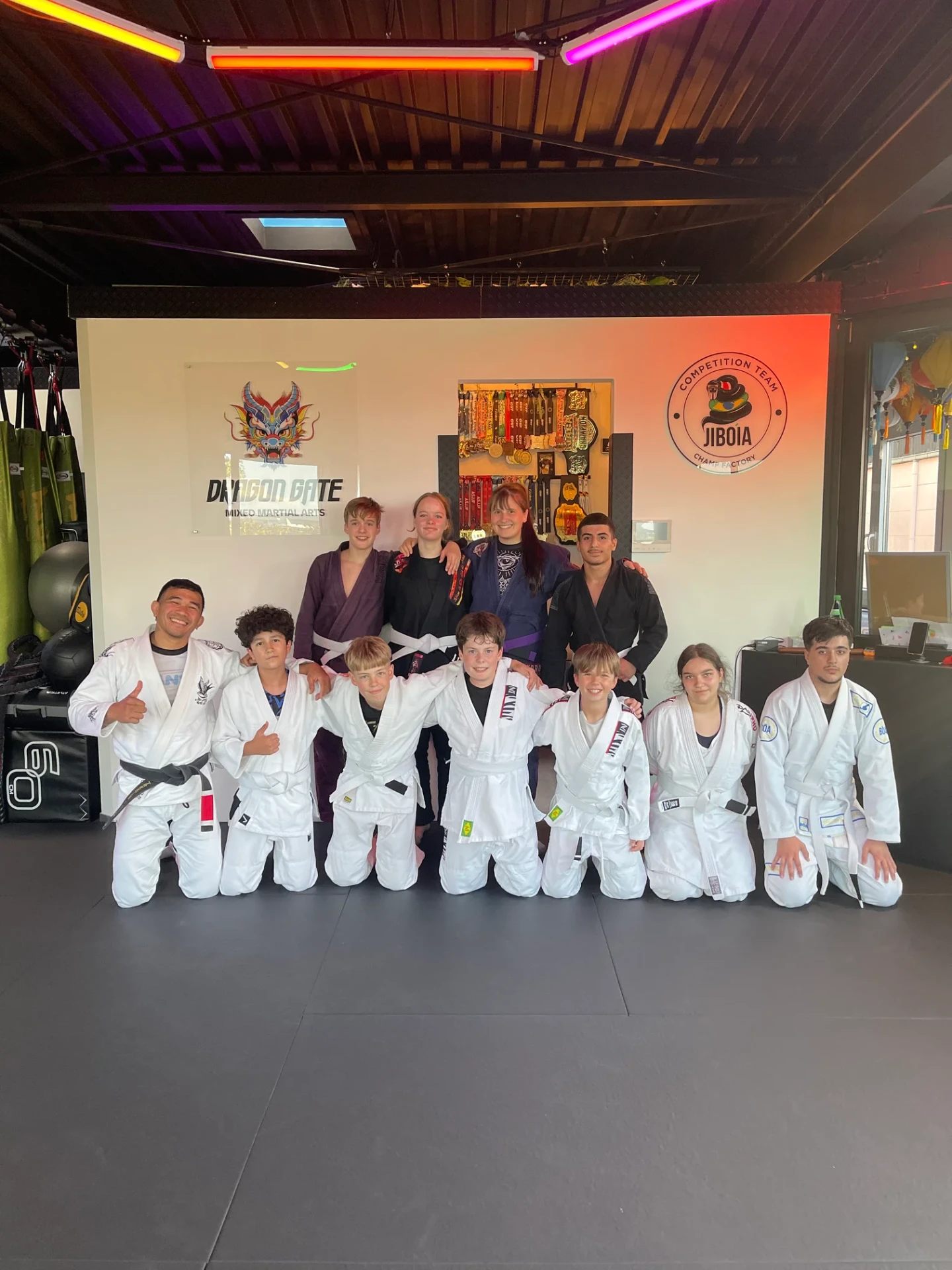 Kids- und Teens-Gruppe im BJJ-Gi mit Trainerteam