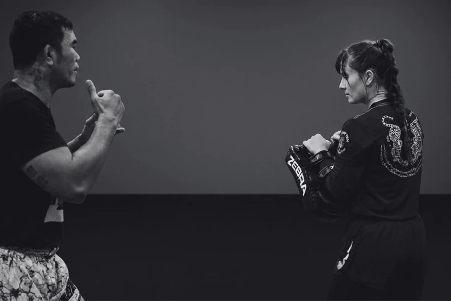 Trainer und Athletin beim Muay-Thai-Training, Schwarz-Weiß-Aufnahme