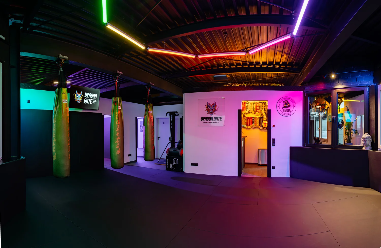 Haupttrainingsraum mit Boxsäcken und Neon-Beleuchtung