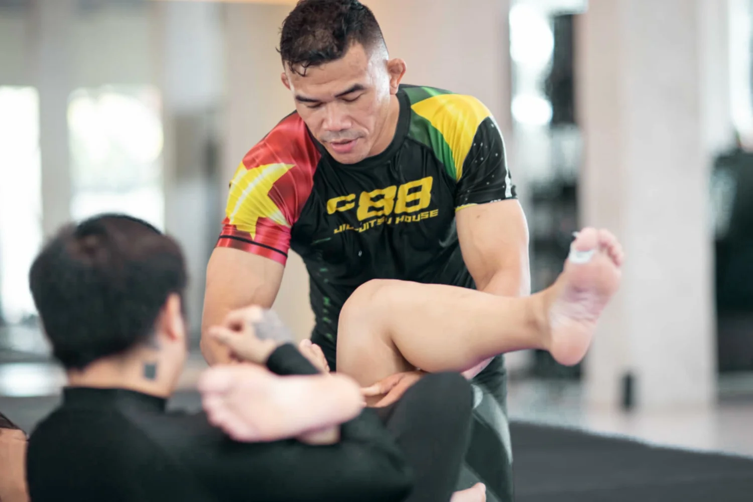 Coach zeigt eine No-Gi-Technik im Drilling